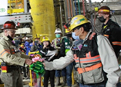 Mark Johnson, Director, Executive Vice President and Chief Operating Officer-PTFI (left), celebrates the successful startup of Crusher 602 with employees at Grasberg Block Cave. 