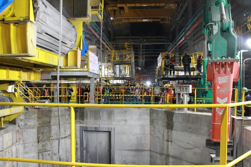 Employees and guests gather at the mouth of the massive feeder of the new crusher during the celebration.