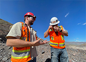 Safford Geologist Lou Shanley (left) describes the mineralogy of a rock sample being closely examined by tour participant Jason Phillips during a stop at the Lone Star pit.