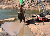 The Verde River has returned to its natural course after the removal of a dam built in 1914; A 100-ton vibratory crane was used to shake panels loose during the removal of a century-old dam that supported a long-closed smelter; Challenging conditions and access issues required the use of both large and small equipment to remove the corrugated steel panels; A heavy crane removes panels in the 320-foot dam on the Verde River.