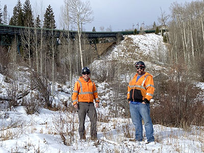 Geoff Niggeler and Kasey Martin stand in an area cleared of vegetation for fire protection.