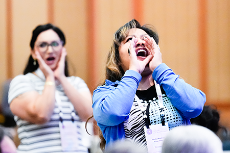 Project DreamCatcher graduates Amanda Mitchell (left) and Talisha Martinez call out their cohort year during the opening session. 